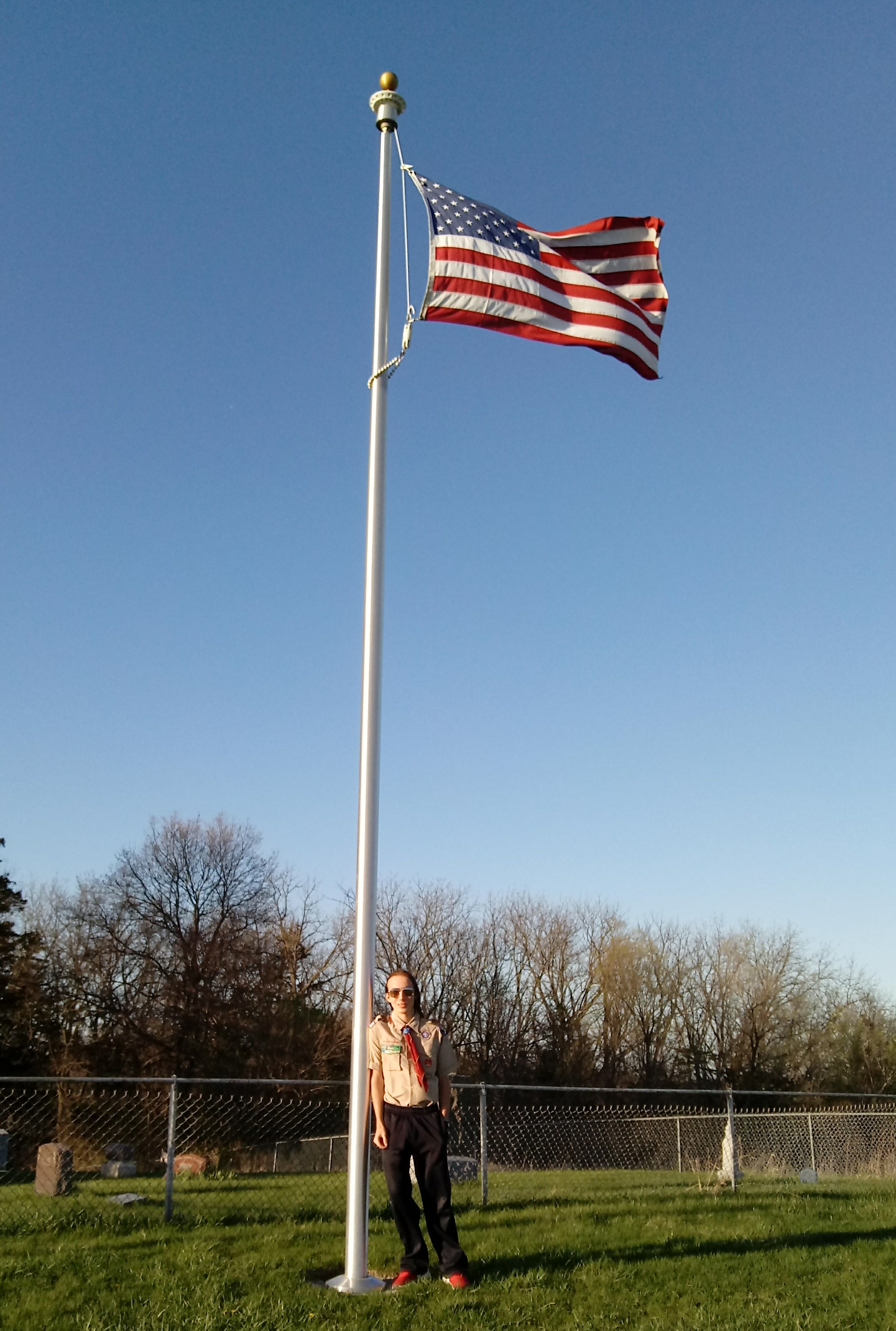 Sam Lawyer with flag pole and new flag installed at Mt Tabor Cemetery
